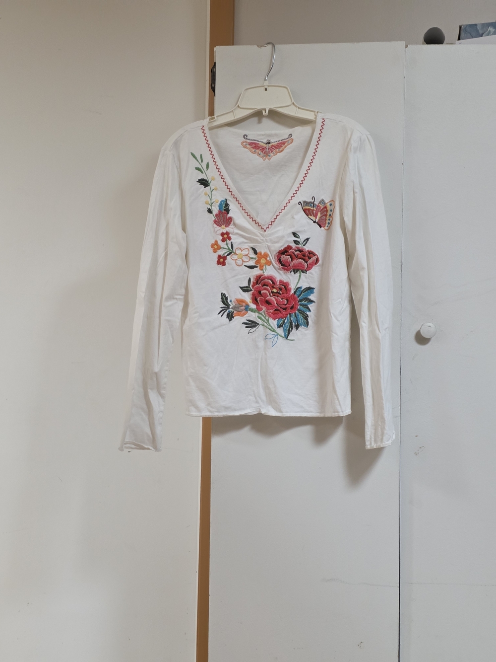 White Long-Sleeve V-Neck Top with Embroidered Floral Motif
